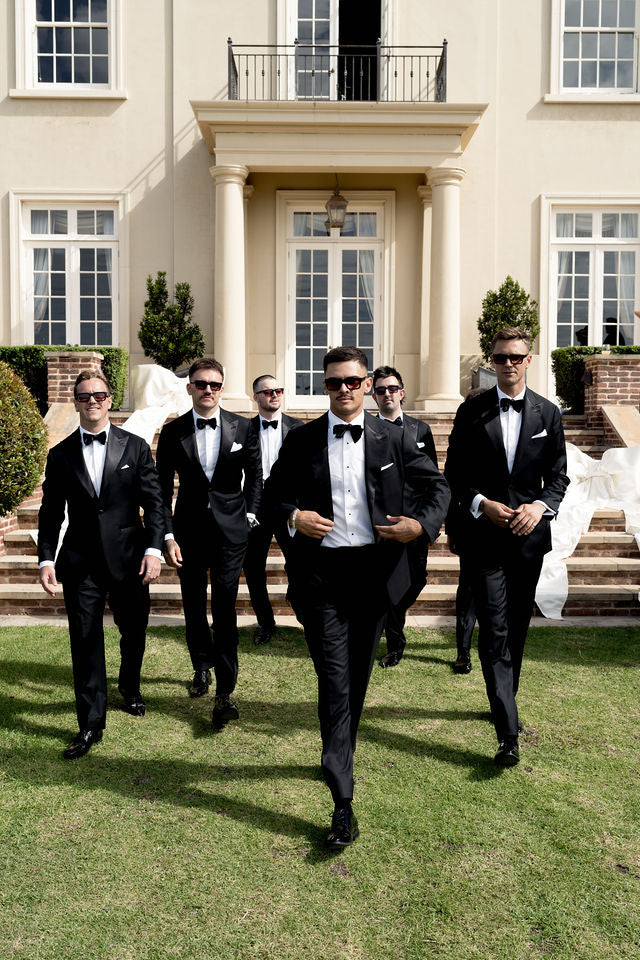 Em and Joel’s wedding party walking down the steps in sunglasses