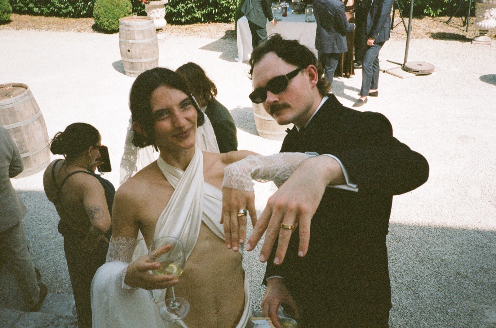 Newlyweds celebrating outside a chateau, with the groom wearing sunglasses
