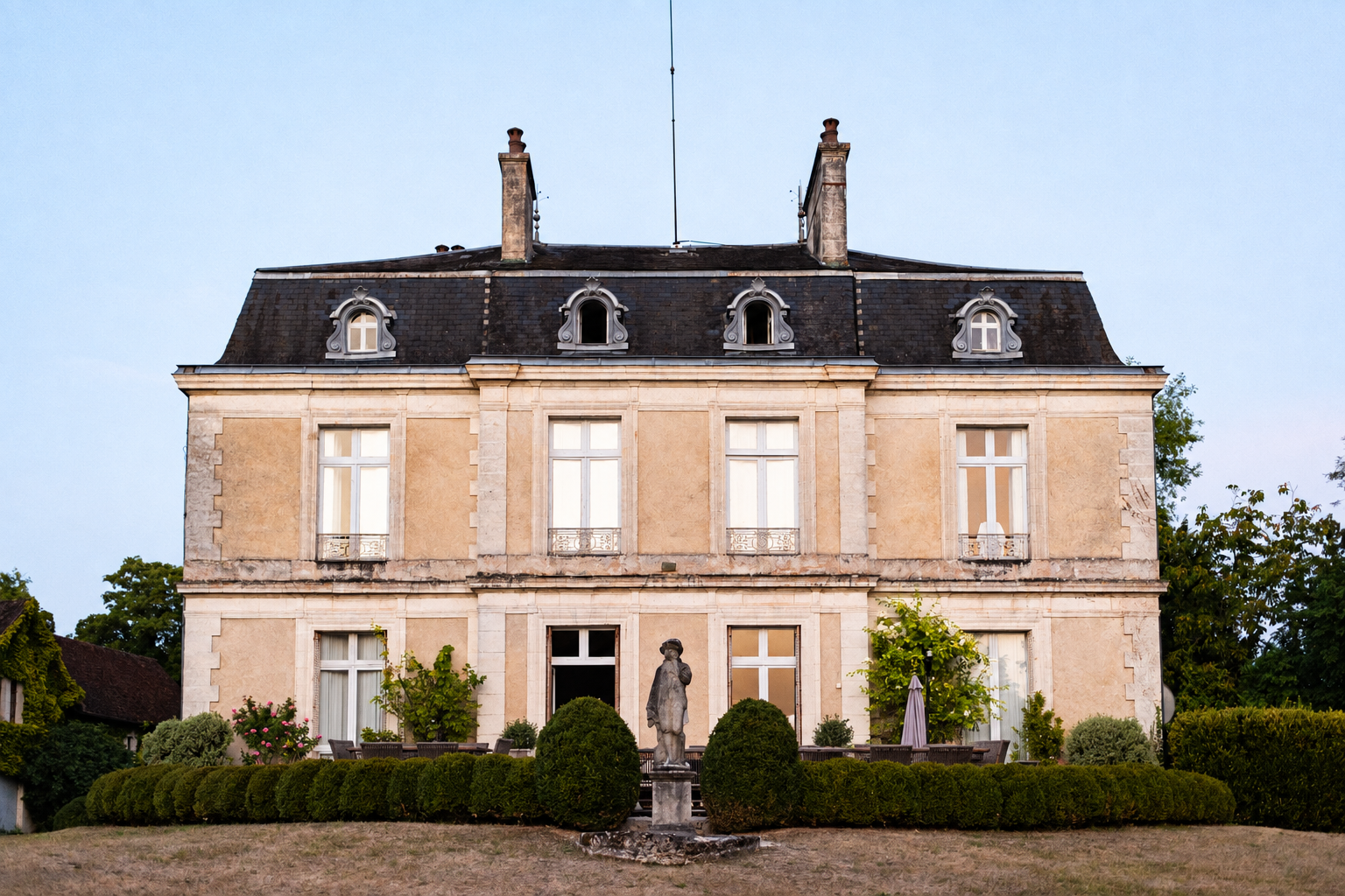 French château with a formal garden and stone statue